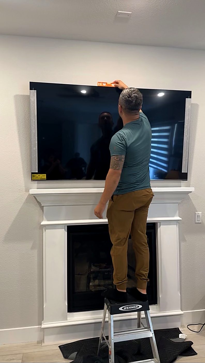 James installing a TV above a fireplace